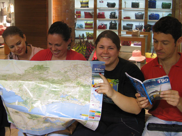 Lorena, de preto, com o marido e as amigas, no shopping pesquisando o mapa do Rio (Foto: Lilian Quaino/G1)