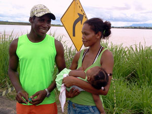 Casal com a filha de 11 meses nos braços vê estrago em estrada do RJ (Foto: Lilian Quaino/G1)