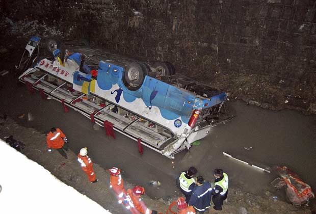 Equipes de resgate e policiais trabalham próximo a ônibus acidentado nesta quarta-feira (4) no condado de Guiding, na província de Guizhou, no sudoeste da China. O ônibus cai de uma ponte coberta de neve, matando ao menos 18 pessoas e ferindo 37, informou nesta quinta-feira (5) a mídia estatal (Foto: AP)