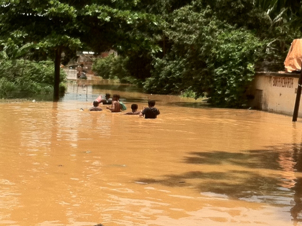 Pessoas nadam na água da chuva (Foto: Lilian Quaino / G1)