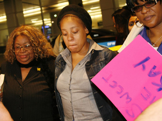 Jakadrien Turner (ao centro), é recebida por sua vó (esq.) e pela sua mãe, no aeroporto de Dallas (Foto: Mike Fuentes/AP)