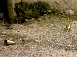 Várias cápsulas de revólver calibre 38 ficaram espalhadas pela calçada (Foto: Reprodução/TV Gazeta)
