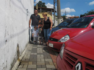 Família se espreme para passar pela calçada (Foto: Renato Jakiitas/G1)