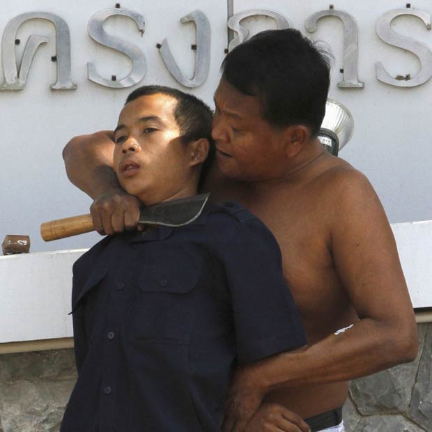 Tailandês identificado como Peak, que sofre de doença renal, mantém homem refém sob ameaça de faca na província de Nonthaburi, na periferia de Bangcoc, nesta segunda-feira (9). O refém devia dinheiro a ele, segundo a polícia. Ele foi libertado após 30 minutos de negociações, e Peak foi preso (Foto: Reuters)