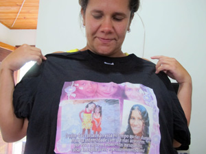 Perla mostra a camiseta com a foto das três filhas vítimas da chuva (Foto: Tássia Thum/G1)
