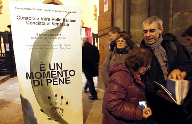 Público forma fila para o lançamento, ao lado de cartaz do calendário, nesta quinta-feira (12) na cidade italiana de Florença (Foto: AP)