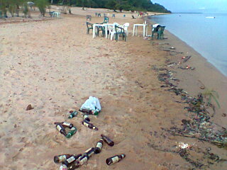 Garrafas e latas de cervejas jogadas ao longo da praia (Foto: Carlos Eduardo Matos/G1 AM)