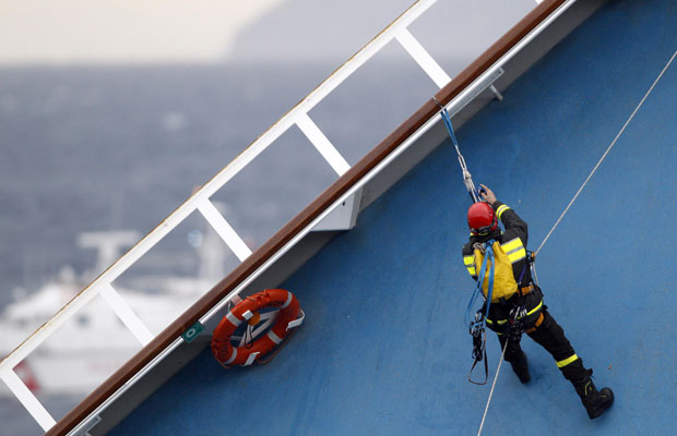 Resgatista escala borda do navio em busca dos desaparecidos após o naufrágio (Foto: Max Rossi/Reuters )