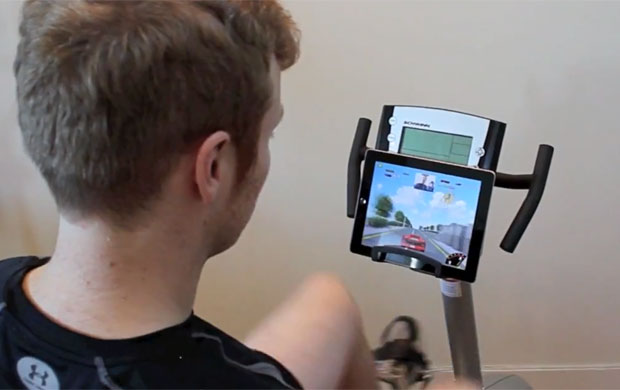 Vibrações da bicicleta ergométrica ao se pedalar são captadas pelo acelerômetro do iPad e controlam a velocidade do carro no game (Foto: Divulgação)