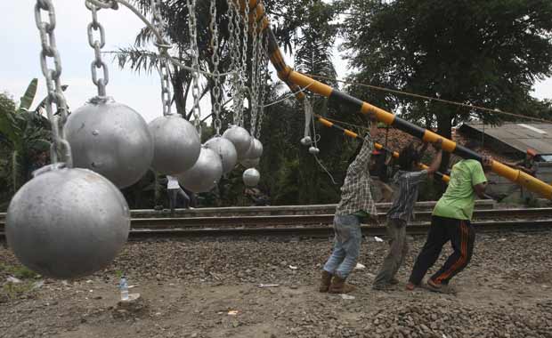 Operários instalam as bolas de concreto em Bekasi nesta terça-feira (17) (Foto: AP)