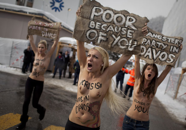Ativistas erguem placas culpando o Fórum Econômico Mundial pela crise econômica (Foto: Anja Niedringhaus/AP)