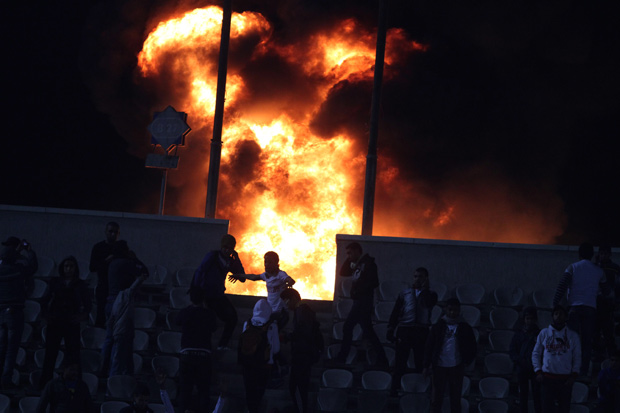 Torcedores põe fogo em Estádio Internacional do Cairo, após jogo ter sido interrompido após as notícias sobre o tumulto em Port Said (Foto: Ahmed Gomaa / AP)