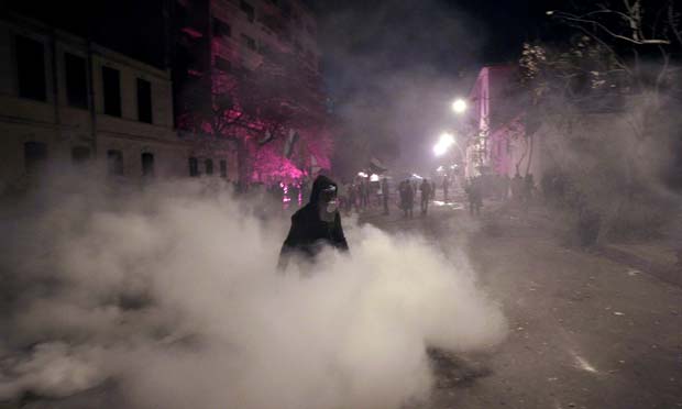 Manifestante egípcio usa máscara contra gás lançado pela polícia no protesto desta quinta-feira (2) no Cairo (Foto: AFP)