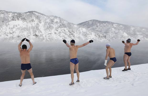 Russos se aquecem antes de nadar no rio. (Foto: Ilya Naymushin/Reuters)