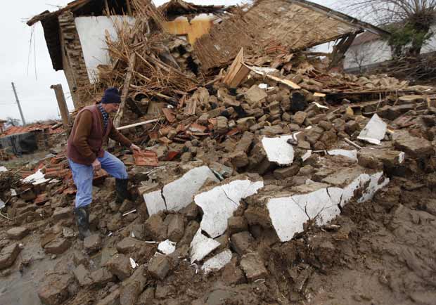 Morador observa os estragos após rompimento de barragem na vila búlgara de Bisser nesta segunda-feira (6) (Foto: AP)