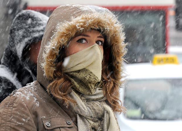 Mulher cobre-se para enfrentar o frio em Skopje, na Macedônia, nesta segunda-feira (6) (Foto: AP)