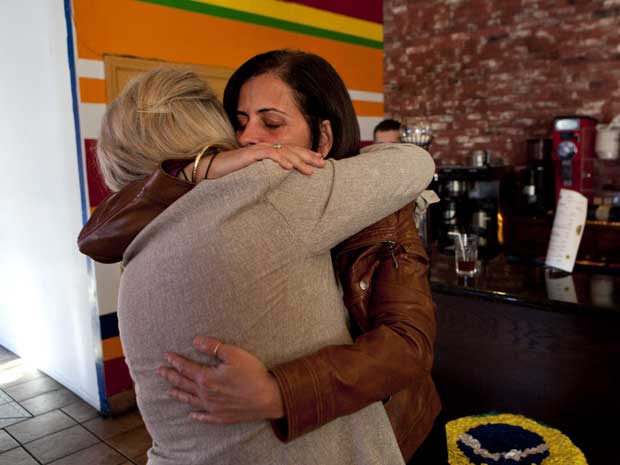 Carla Burgos (à direita), irmã de Mônica, abraça advogada Alison Triessl, após os EUA extraditarem Bruce Beresford-Redman para o México. (Foto: Jae C. Hong / AP Photo)