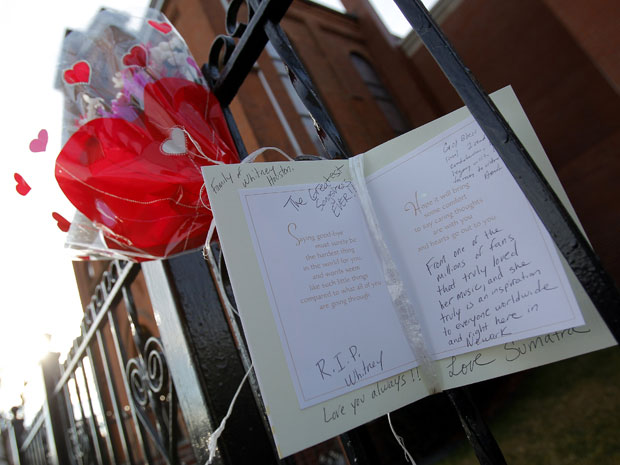 Flores e cartaz foram deixados em frente à igreja onde Whitney cantava no coral, em Newark (Foto: Reuters)