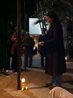 Fã acende vela em homenagem à cantora em frente ao hotel Beverly Hilton neste sábado (11) (Foto: Mariana De Lucca/G1)