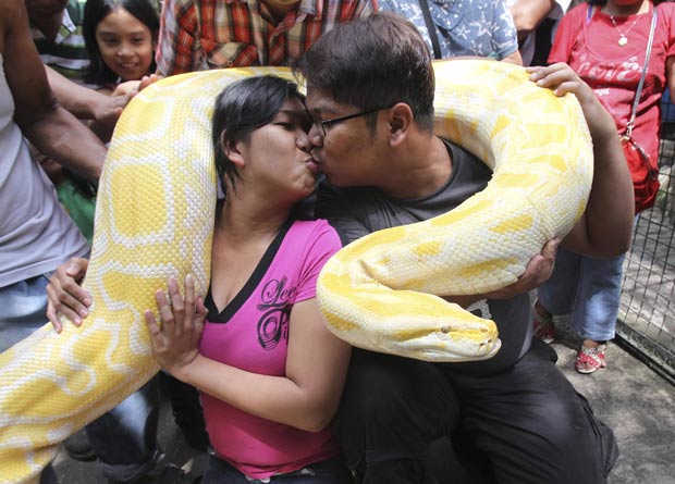 Casal Eroll Escobar e Princess Madrolejo comemorou Dia dos Namorados abraçado com uma cobra de 4,87 m. (Foto: Romeo Ranoco/Reuters)