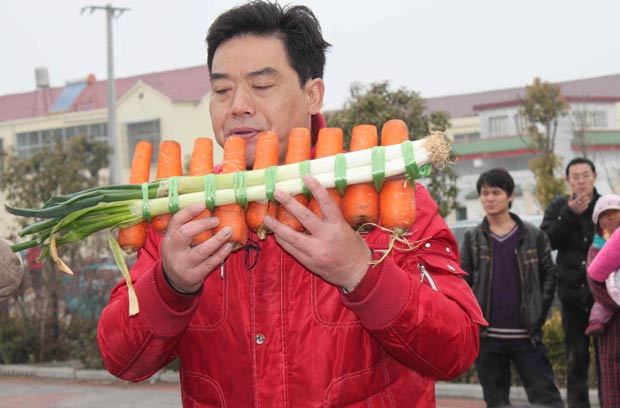 Nan Weidong toca instrumento feito com cenouras. (Foto: China Daily/Reuters)