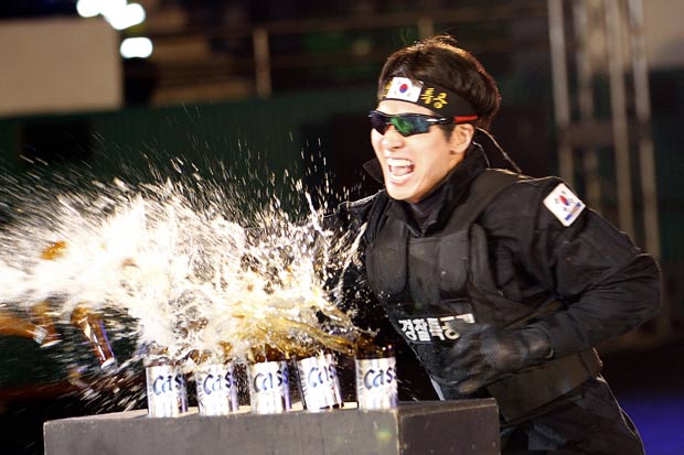 Policial destrói garrafas cervejas com golpe com a mão. (Foto: Lee Jin-man/AP)