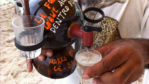 O ambulante Samuel Alves, de Fortaleza, vende cachaça dentro de cocos secos (Foto: Giselle Dutra/G1 Ceará)