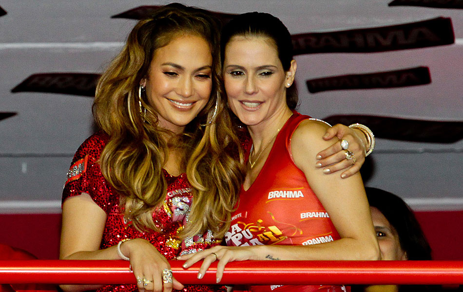 Jennifer Lopez e Débora Secco se abraçam em um camarote no primeiro dia de desfiles no Rio de Janeiro.