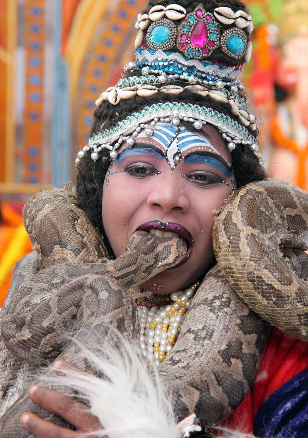 Adolescente põe cobra na boca. (Foto: Ajay Verma/Reuters)