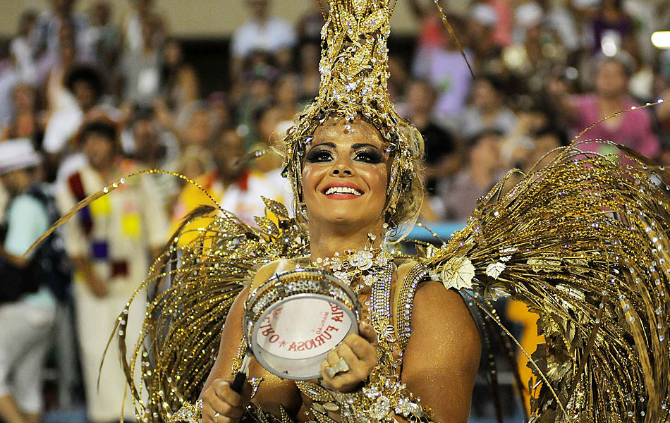 Viviane Araújo toca tamborim durante o desfile de sua escola.