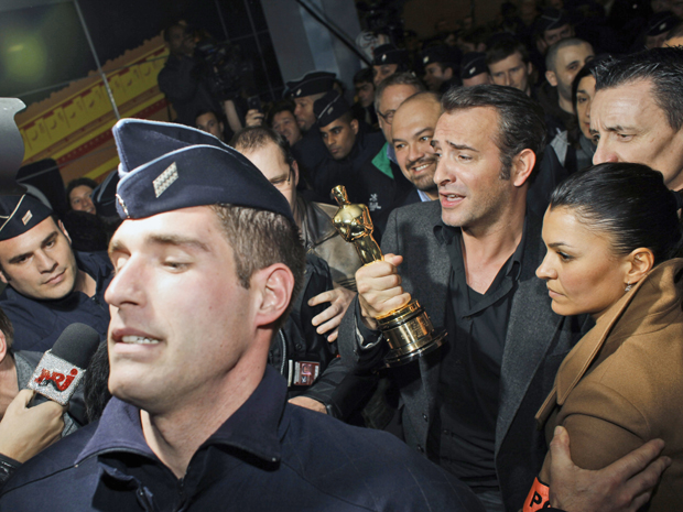 Cercado por multidão, Jean Dujardin chega à França após vencer o Oscar na categoria melhor ator (Foto: Thibault Camus/AP)
