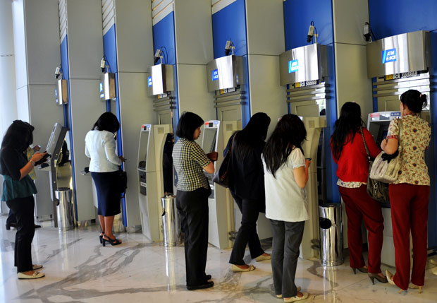 Indonésias fazem fila em caixas eletrônicos da capital, Jacarta (Foto: Adek Berry / AFP)