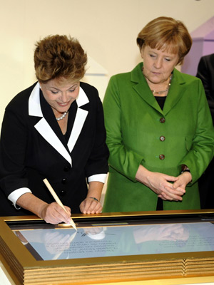 Chanceler alemã, Angela Merkel, e a presidente Dilma Rousseff assinaram o 'livro de ouro' digital da Microsoft (Foto: Nigel Treblin/AP)