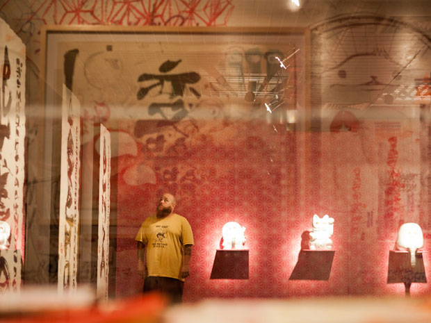 Felipe Yung, o Flip, posa ao lado de suas obras de arte (Foto: Caio Kenji/G1)
