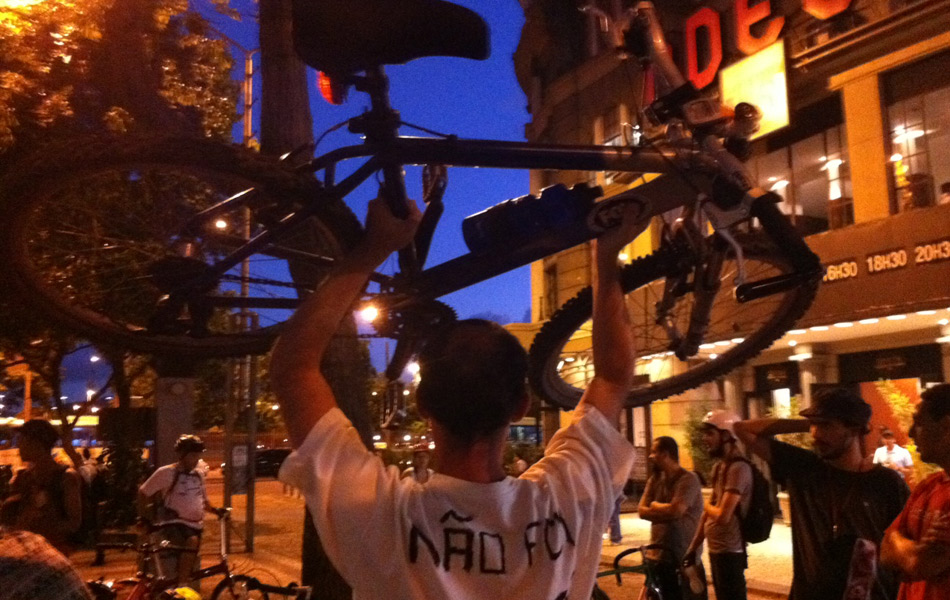 Ciclistas se concentram na Cinelândia, no Centro do Rio, no início da noite desta terça-feira (6), para a chamada "bicicletada". Os participantes preparam um cartaz com o desenho de um carro se transformando em arma. 