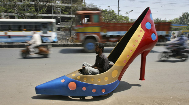 Homem testa carro em formado de sapato de salto alto em rua da cidade indiana de Hyderabad nesta quarta-feira (7). Criado pelo designer automobilístico Sudhakar Yadav, o veículo é uma homenagem ao Dia Internacional das Mulheres, celebrado na quinta. Ele atinge 45 quilômetros por hora, segundo seus criadores (Foto: Krishnendu Halder/Reuters)