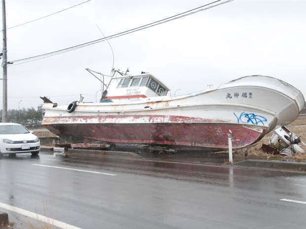 Um ano após o tsunami, um barco continua ao lado de uma estrada de área atingida pela onda gigante no Japão (Foto: Roberto Kovalick/TV Globo )