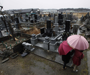 Família visita cemitério em respeito às vítimas do tsunami na cidade de Hirono. (Foto: Reuters)