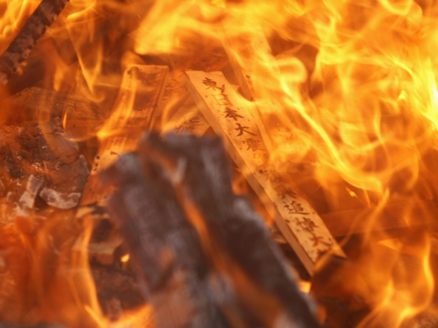 Varas de oração são queimadas dentro de fogo sagrado durante um ritual budista para consolar as almas daqueles que foram mortos no 11 de março (Foto: Reuters)