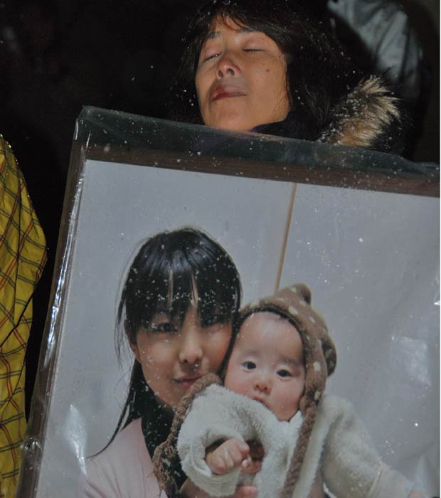 Japonesa segura o retrato da filha e do neto de seis meses mortos no tsunami. Ela participou da homenagem às vítimas em uma queima de fogos na montanha de  Izumigaoka, em Sendai, a maior cidade atingida pelo tsunami. (Foto: Roberto Kovalick/TV Globo)