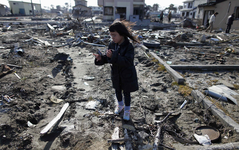 Criança visita local onde ficava sua casa, Higashimatsushima, antes do tsunami