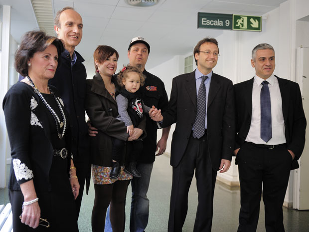 No colo dos pais, Alaitz posa para foto com os médicos que a trataram (Foto: AFP Photo/Josep Lago)