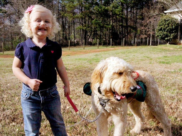 Alida Knobloch com Mr. Gibbs, o cão que carrega seu tubo de oxigênio (Foto: Caters News)