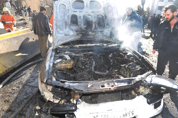 Carro destruído nos ataques deste sábado (17) em Damasco, capital da Síria (Foto: AP)