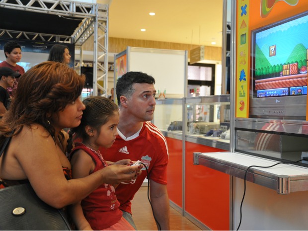 Família jogando Supermario, game que já foi um dos mais populares (Foto: Felipe Bastos/G1 MS)