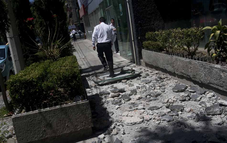 Homem anda sobre escombros caídos de um prédio após forte abalo, na Cidade do México