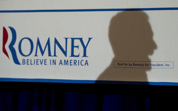 Sombra de Romney é projetada em cartaz de campanha durante discurso em Metairie, na Louisiana, na sexta (23) (Foto: Steven Senne / AP)