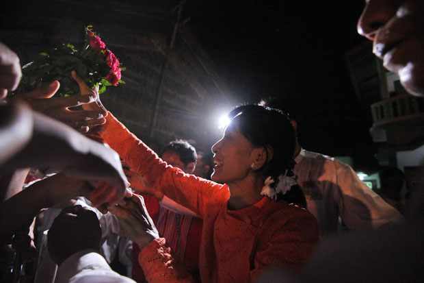 Aung San Suu Kyi recebe flores em Kawhmu na noite de sábado (31), véspera da votação (Foto: Soe Than Win/AFP)