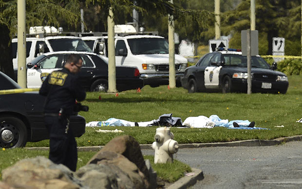 Corpos cobertos no gramado da escola Oikos University, em Oakland, na Califórnia, que foi invadida por atirador nesta segunda-feira (2) (Foto: Noah Berger / AP)