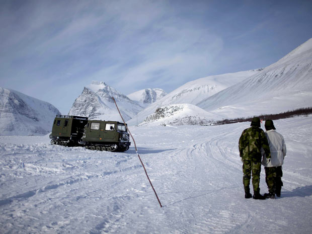 Militares suecos observam avião norueguês em região do Ártico. Derretimento do gelo deve abrir novas rotas comerciais e iniciar conflitos. (Foto: Stian Lysberg Solum/Scanpix Norway/Reuters)